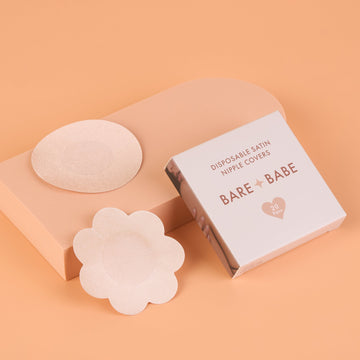 Satin Nipple Pasties box, disposable satin nipple covers, 20 pairs, with one round and one flower-shaped pasty in Creme on a peach backdrop.