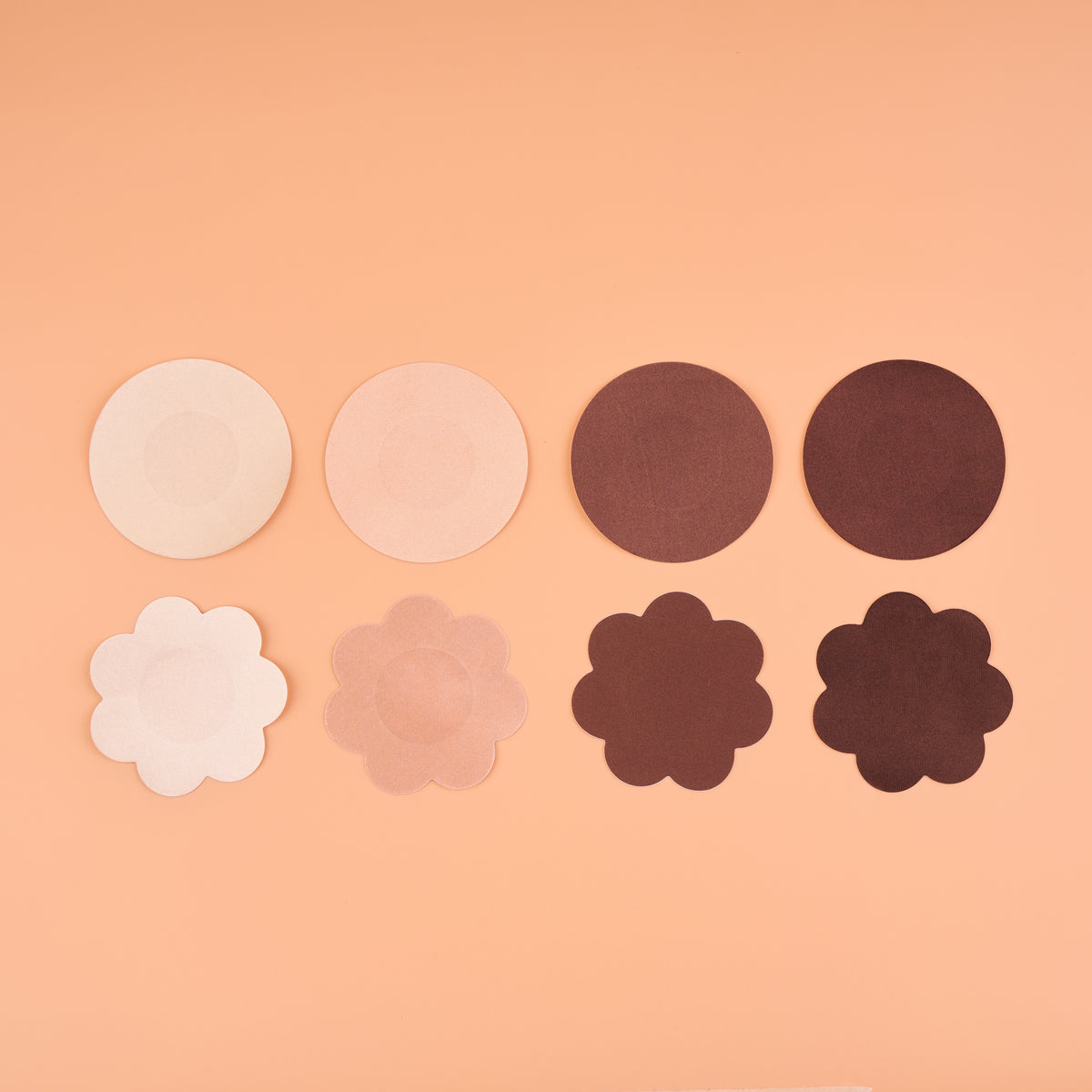 Satin Nipple Pasties in round and flower shapes, shown in four shades: disposable fabric nipple covers, 6.5 cm across, that lie flat under thin tops. Each box holds 20 pairs, 10 round and 10 flower.