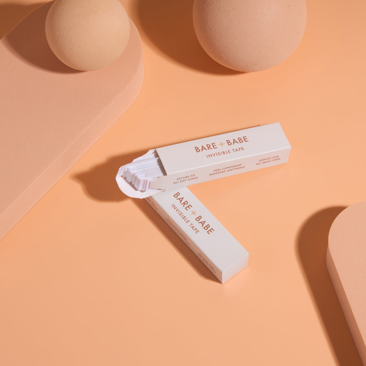 Invisible Lingerie Tape: two open boxes with stacks of pre-cut strips spilling out, travel-size double-sided fashion tape for keeping outfits in place.
