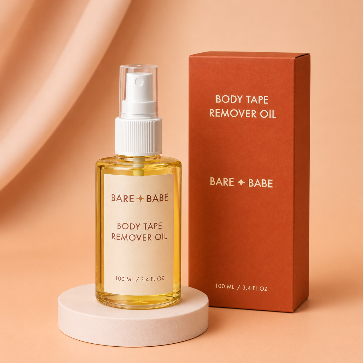 Boob Tape Remover Oil: a 100 ml / 3.4 fl oz spray bottle of golden oil on a pedestal beside its rust-red Body Tape Remover Oil box, for gentle removal of boob tape, body tape and lingerie tape adhesive.