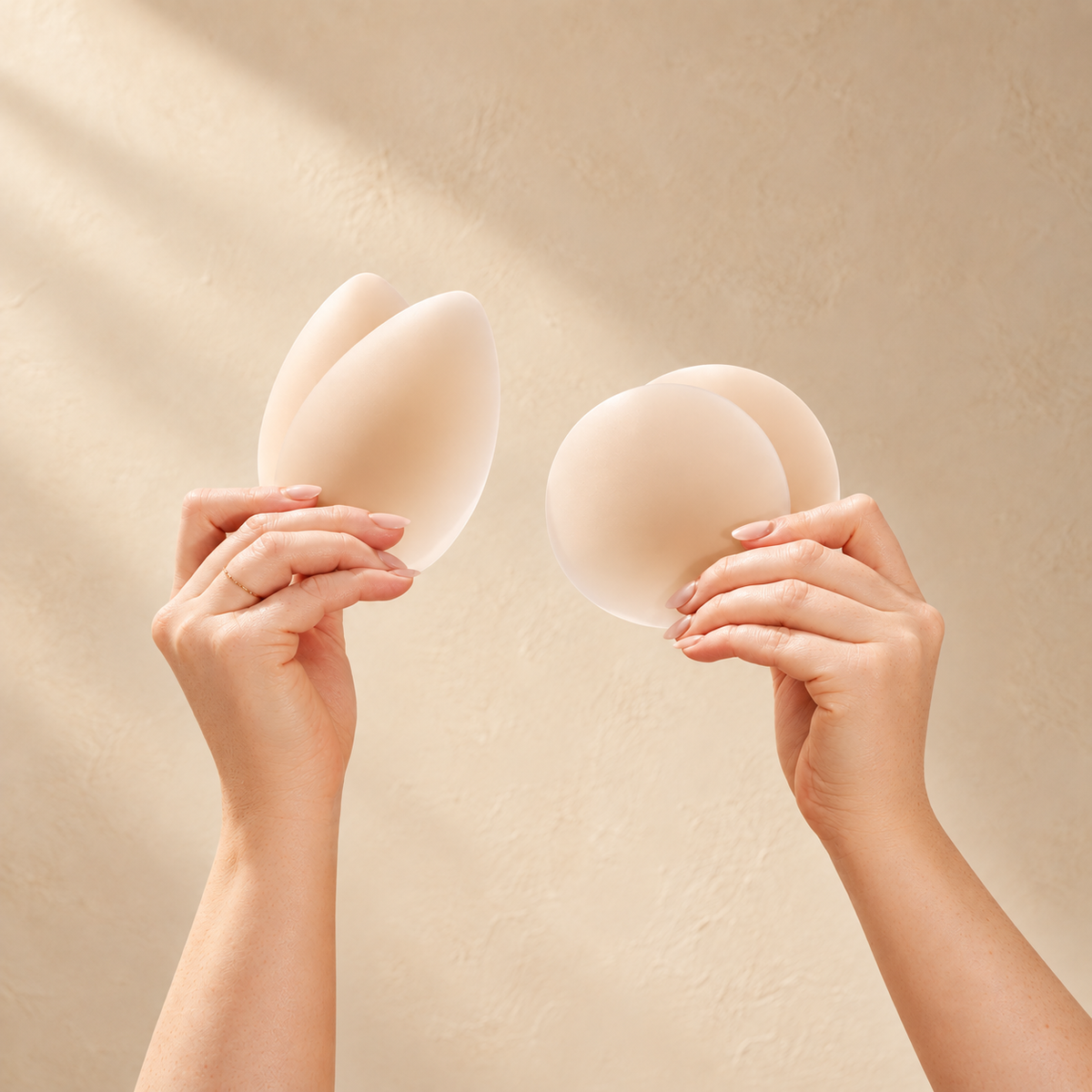 Round and Triangle Nipple Cover Set: two hands holding a pair of Triangle Adhesive Nipple Covers and a pair of round Adhesive Nipple Covers, reusable silicone nipple covers for more necklines