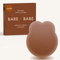 Lifting Nipple Covers (Two-Tabs) in Cocoa: two-tab reusable silicone lift nipple cover in front of its Cocoa Bare Babe box, labelled Lifting, invisible nipple covers, medical grade silicone