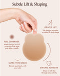 Lifting Nipple Covers (Two-Tabs) in Honey, features: subtle lift and shaping, tab design for gentle lift and shape, matte full coverage under tight and sheer clothes, ultra-thin edges that blend with your skin, and strong adhesive that stays put through activity. Hand holds the silicone lift cover by its tabs