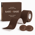 Boob Tape Kit in Mocha: a roll of deep brown breast lift tape with grid backing for cutting strips, two matching round satin pasties to cover the nipple first, and the Mocha box marked medical-grade adhesive.