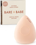 Sensitive Triangle Nipple Covers in Creme: a rounded-triangle sticky silicone nipple cover marked Sticky, with its adhesive-free center ring, in front of the Creme Bare Babe box in medical-grade silicone.